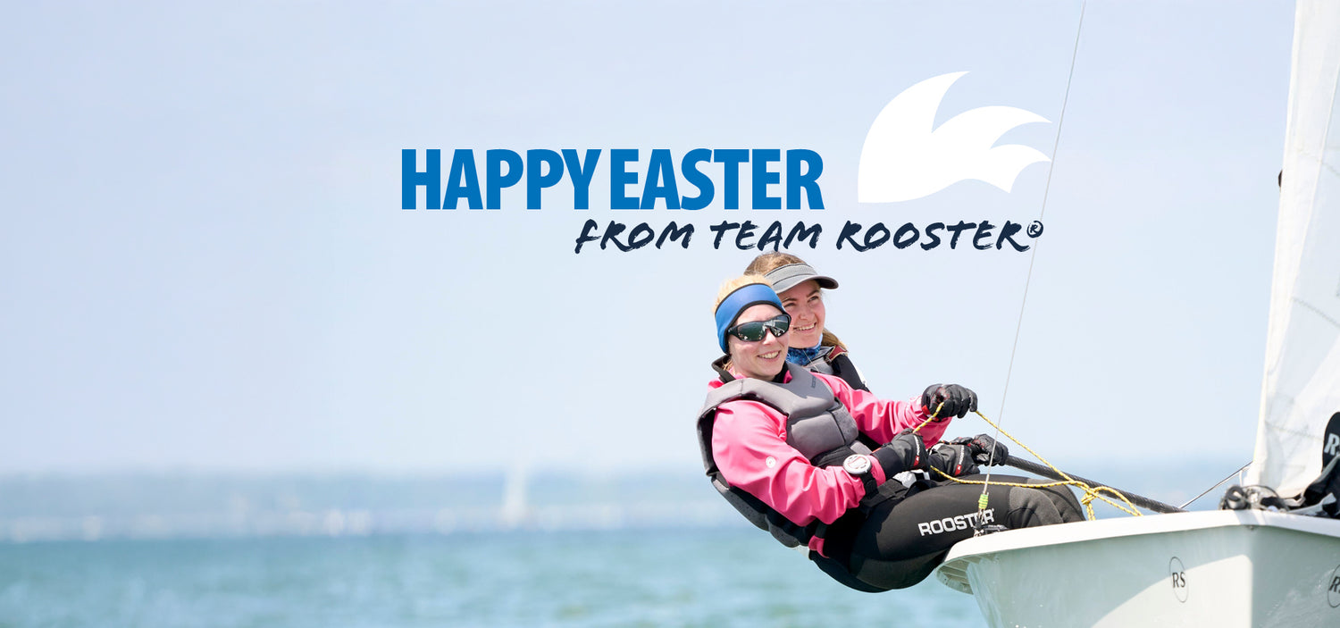 Two smiling sailors in Rooster-branded gear lean out of a sailboat on the water, with a clear sky and the text 'Happy Easter from Team Rooster®' above them.